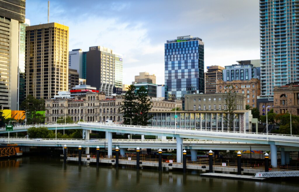 Brisbane city skyline with buildings and trees at dusk
